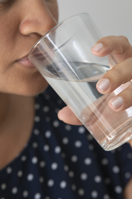 Une femme qui boit un verre d'eau