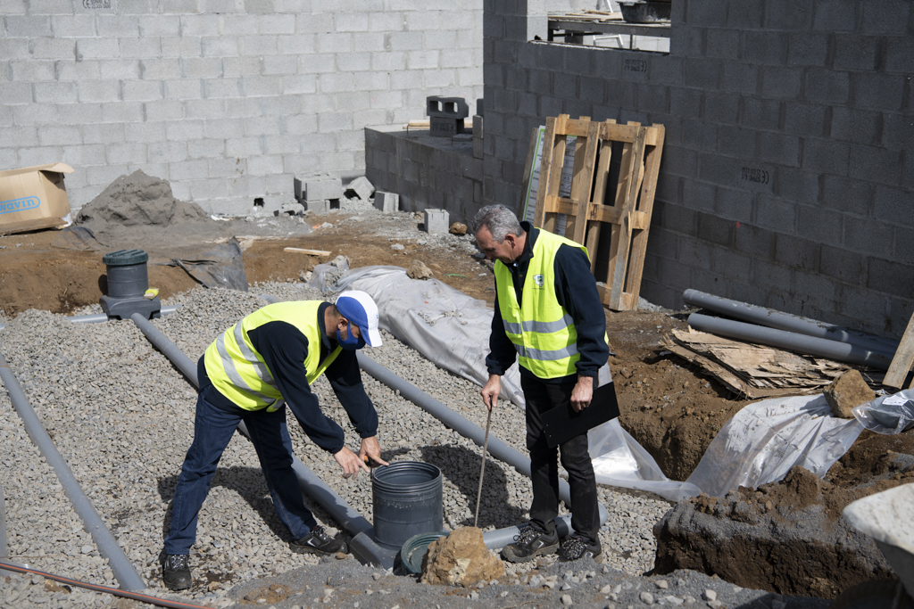 Des hommes sur un chantier qui prennent des mesures