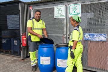 Deux personnes qui ouvrent des poubelles pour les huiles de friture